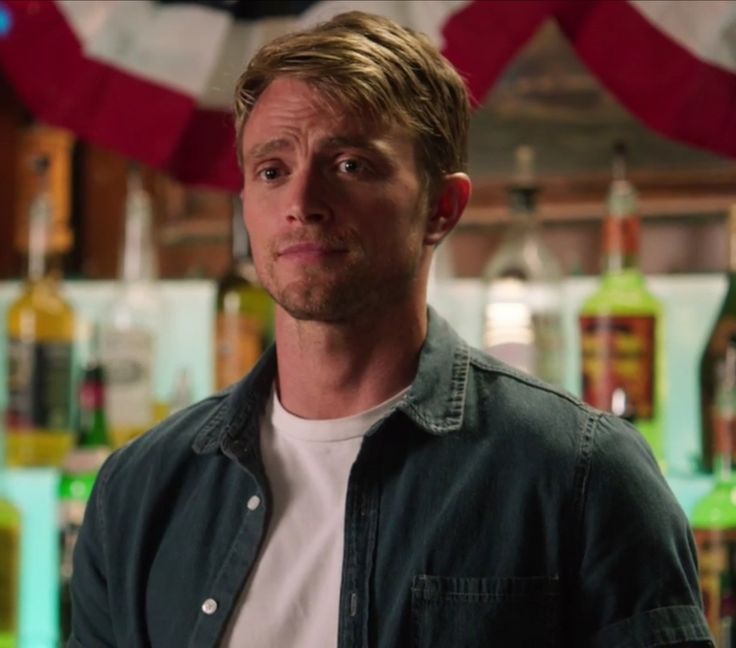 a man standing in front of liquor bottles