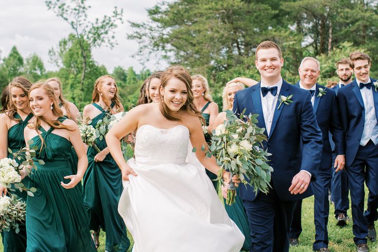 a bride and groom walking with their bridal party in the background at a wedding