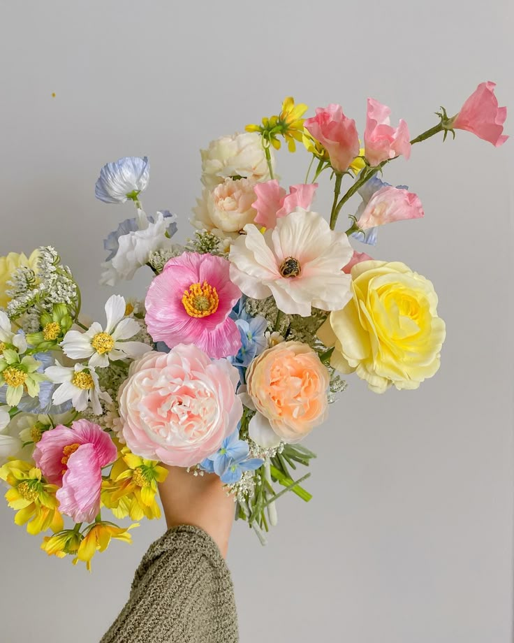 a person holding a bouquet of flowers in their hand