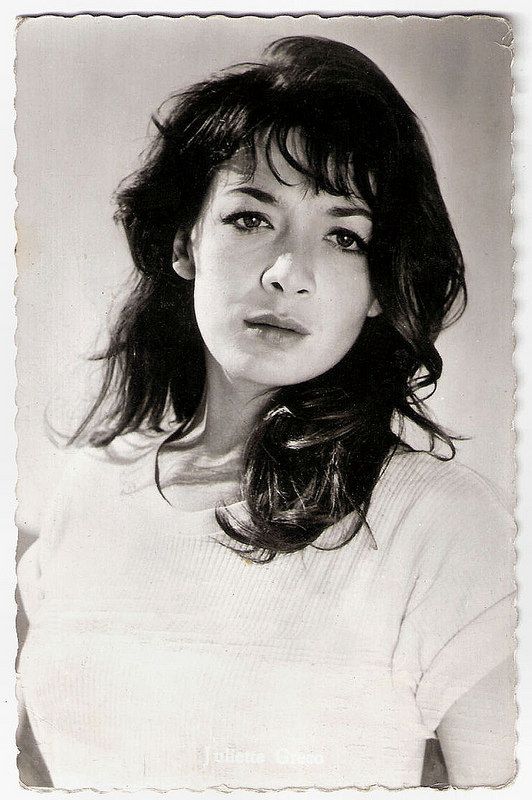 an old black and white photo of a woman with long dark hair wearing a sweater