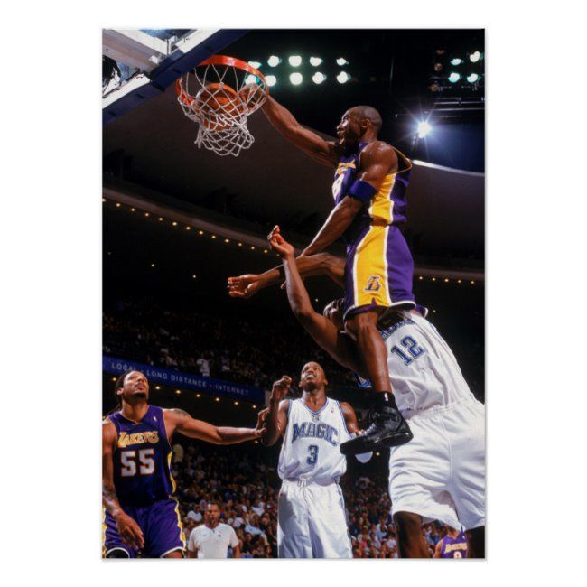 a basketball player jumping up to dunk the ball in front of two other players