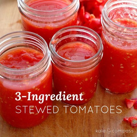 four jars filled with red sauce sitting on top of a wooden table