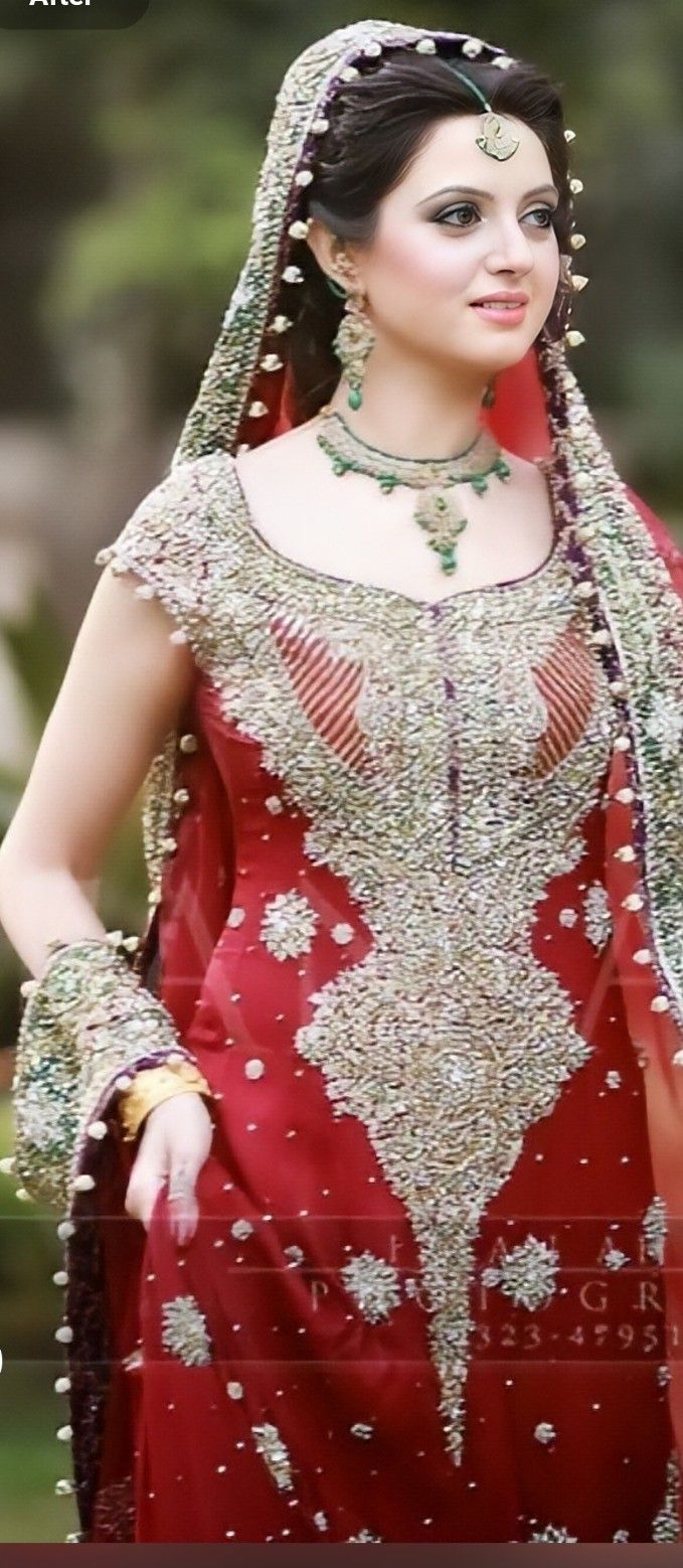 a woman wearing a red and gold bridal gown