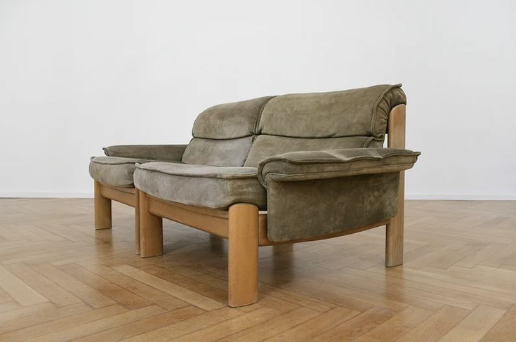 a couch with two pillows sitting on top of it in a room next to a wooden floor