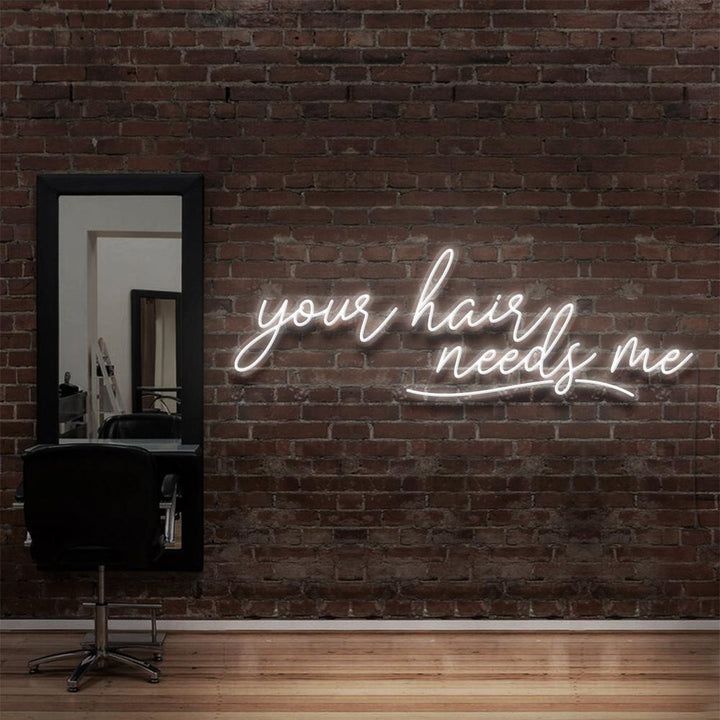 a brick wall with a neon sign that says, your hair needs me