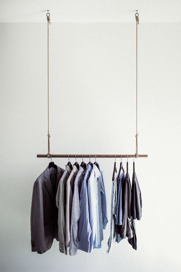 a rack with shirts hanging from it's sides and clothes on the hangers