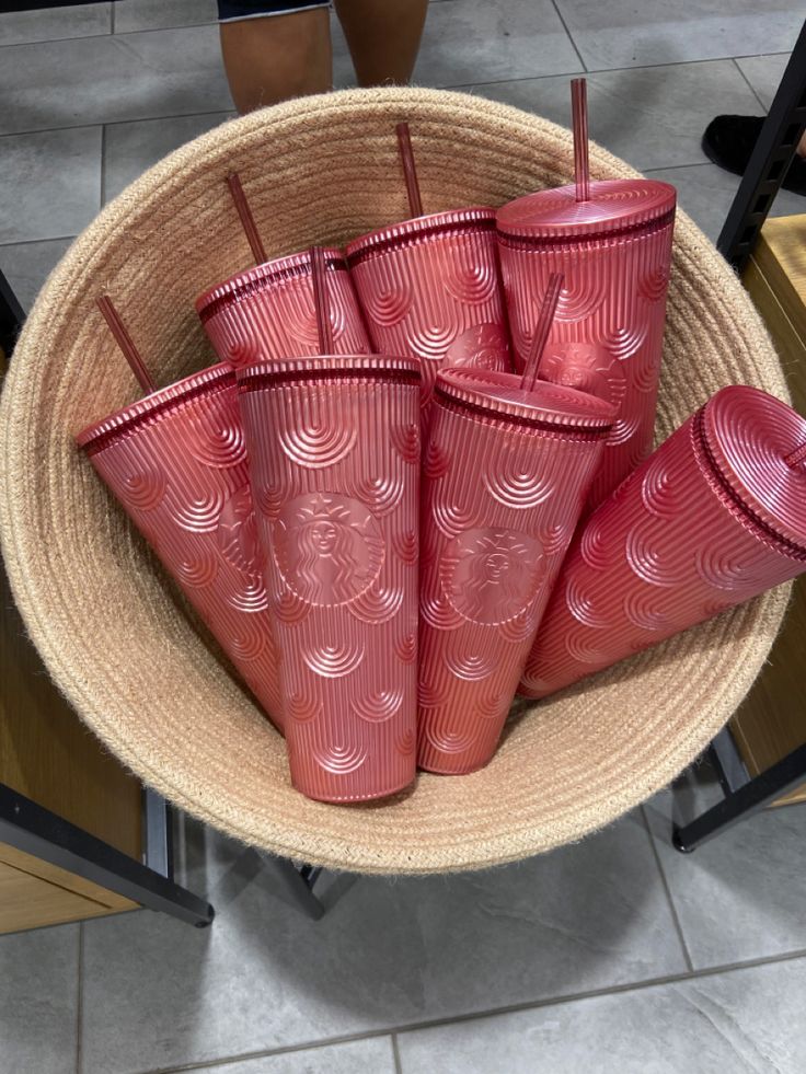 six red cups sitting in a basket on the floor