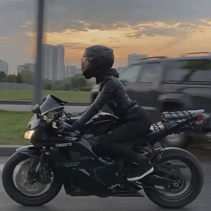 a man riding on the back of a motorcycle down a street