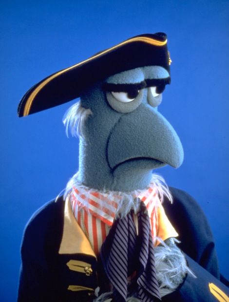 the muppet is dressed in an uniform and tie