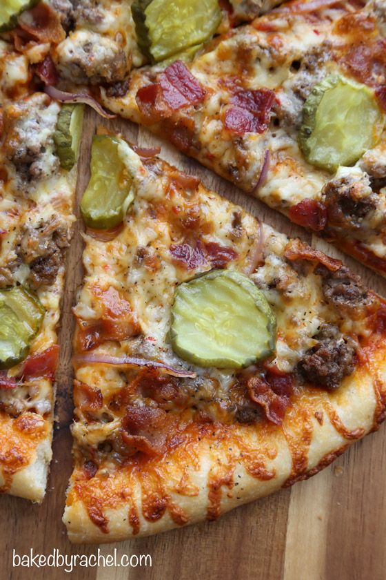 a pizza with several toppings cut into slices on a wooden cutting board and ready to be eaten