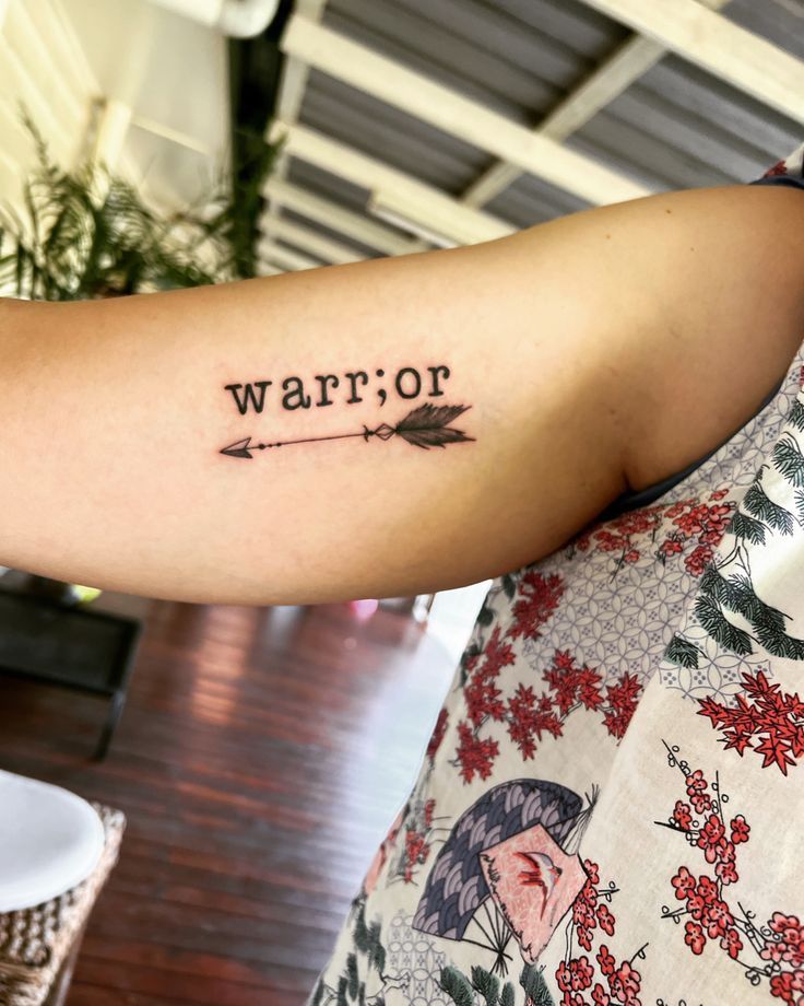 a woman with a tattoo on her arm that says warriof and an arrow