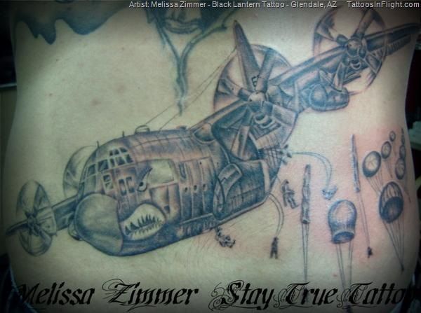 the back of a man's chest with an airplane and other things on it