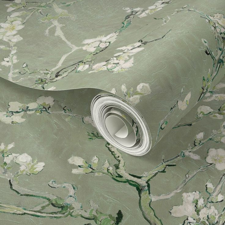 a green wallpaper with white flowers on it and a roll of silver paper next to it