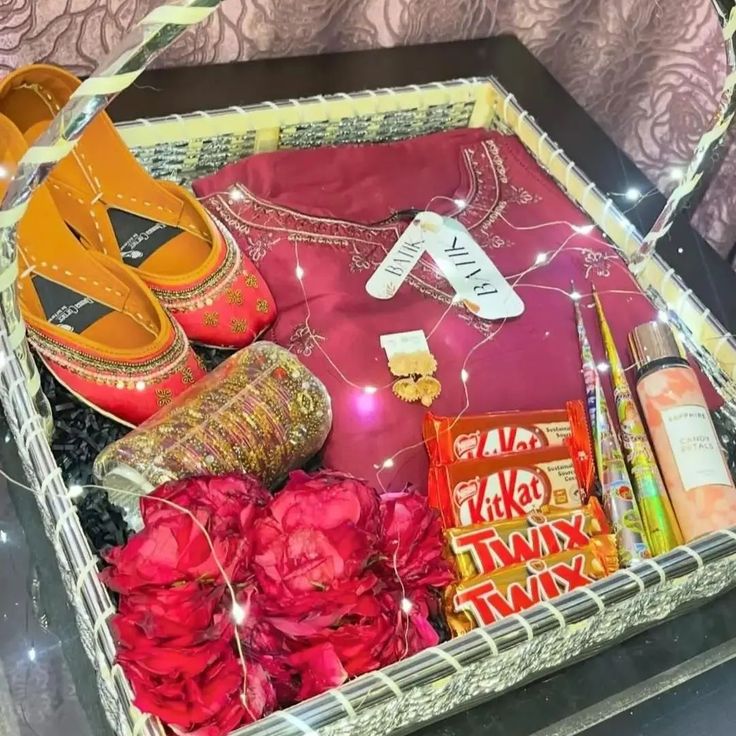 an open suitcase filled with shoes, flowers and other personal care items on top of a bed