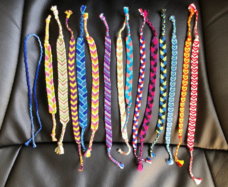 several different colored bracelets are lined up on a couch