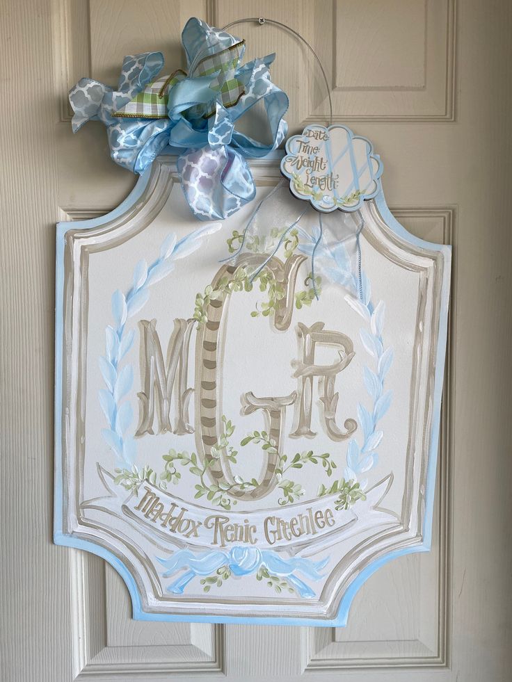 the front door is decorated with blue and white ribbons, bows, and monogrammed letters