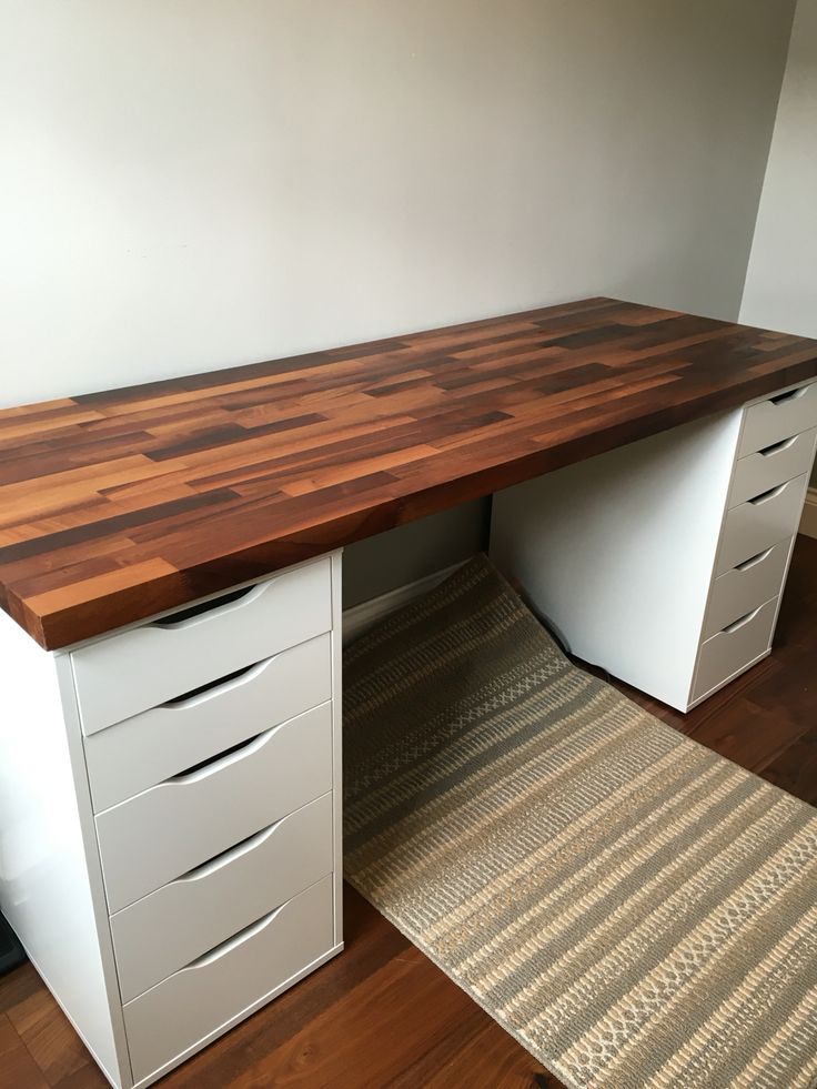 a desk with drawers and a rug on the floor