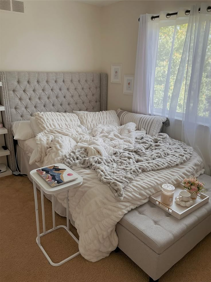 an unmade bed in a bedroom with white linens and pillows on the headboard