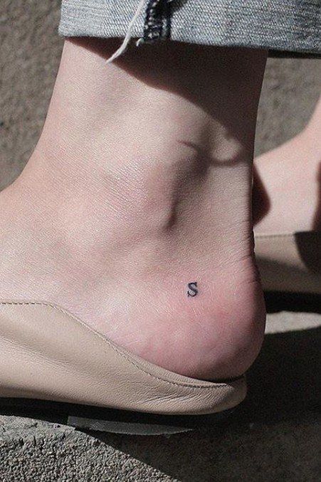 a woman's foot with a small tattoo on the side of her ankle,