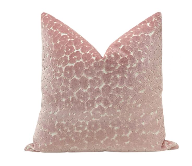 a pink and white pillow with spots on it's back, in front of a white background