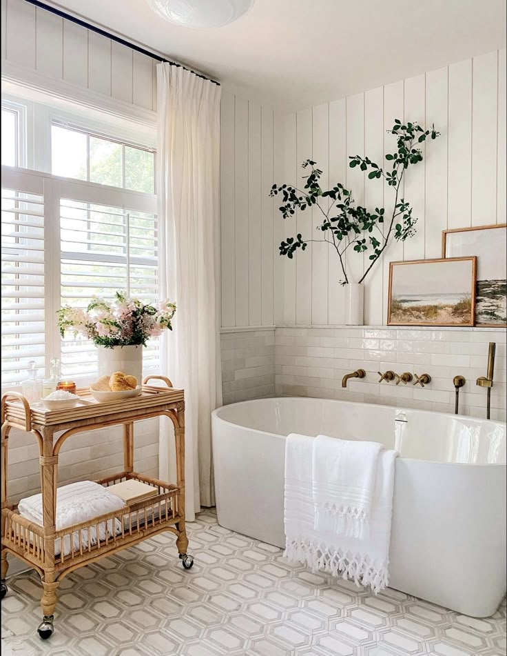 a bathroom with white walls and flooring has a plant in the bathtub next to the tub