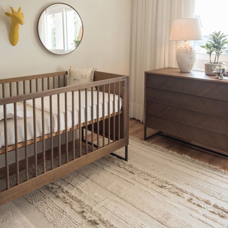 a baby crib in the corner of a room next to a dresser and window