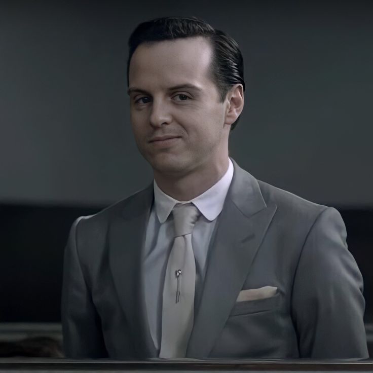 a man in a suit and tie is looking at the camera with an intense look on his face