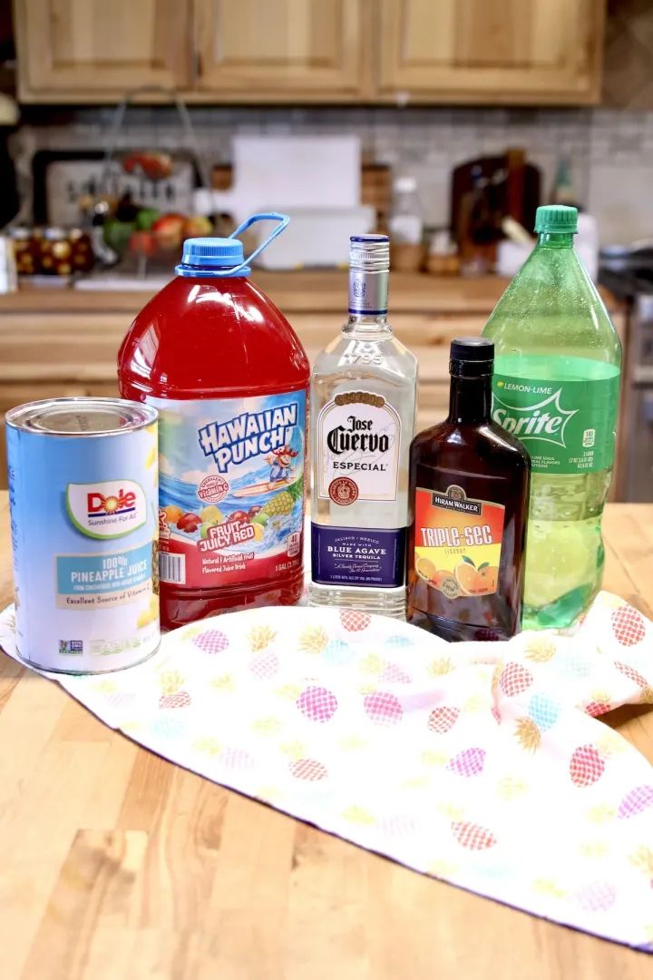 several bottles of alcohol are sitting on a kitchen counter next to a tea towel and an oven mitt