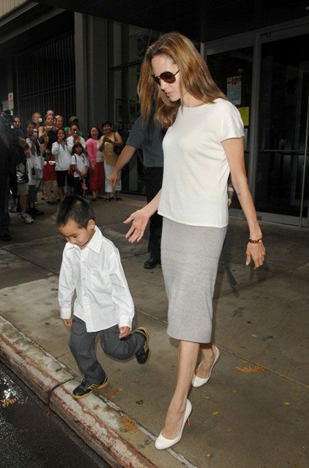 a woman walking next to a little boy