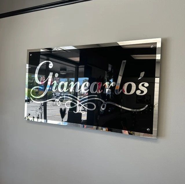 a glass sign hanging on the side of a wall next to a window that says chanaro's