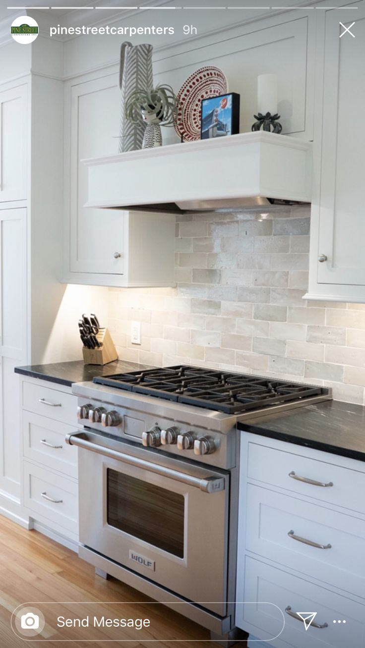 a stove top oven sitting inside of a kitchen next to white cabinets and counter tops