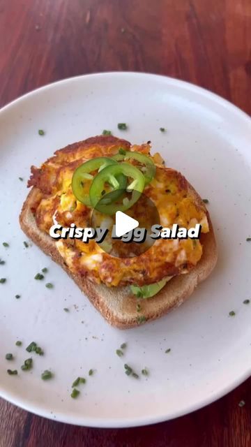 a white plate topped with a piece of bread covered in cheese and veggies