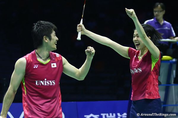 two men holding tennis racquets high in the air