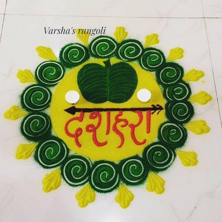 an image of the name varsha's rangoli in red, green and yellow