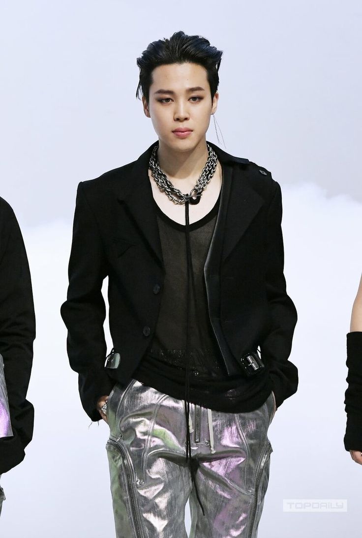 a male model in a black jacket and silver pants