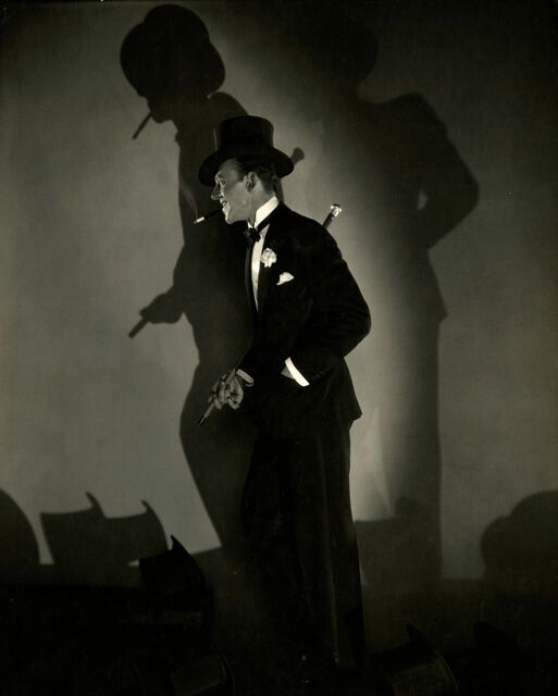 a man in a suit and top hat standing with his hands on his hips