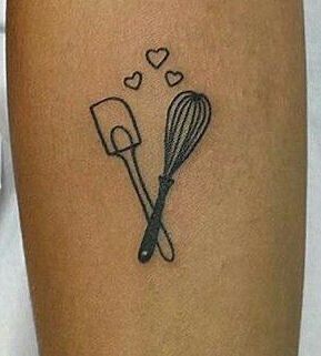 a woman's leg with a tattoo on it that has cooking utensils and hearts