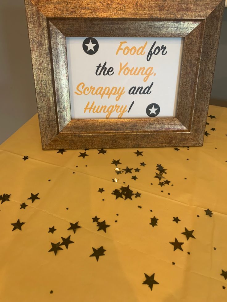 a wooden frame sitting on top of a table filled with star shaped confetti