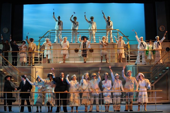 a group of people standing on top of a boat