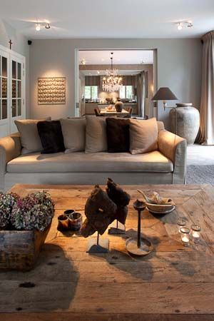 a living room filled with furniture and lots of pillows on top of a wooden floor