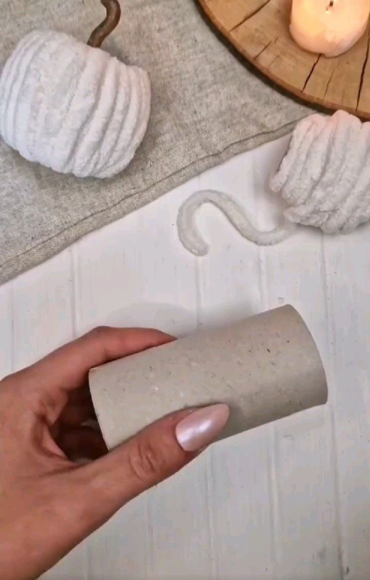 a person holding a roll of toilet paper in front of a wooden tray with candles