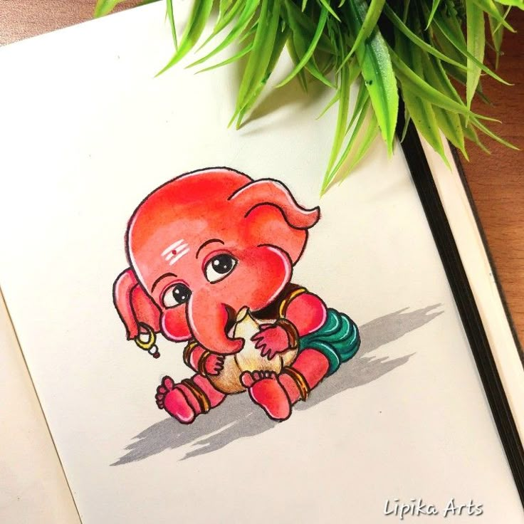 an elephant is drawn on paper next to a potted plant