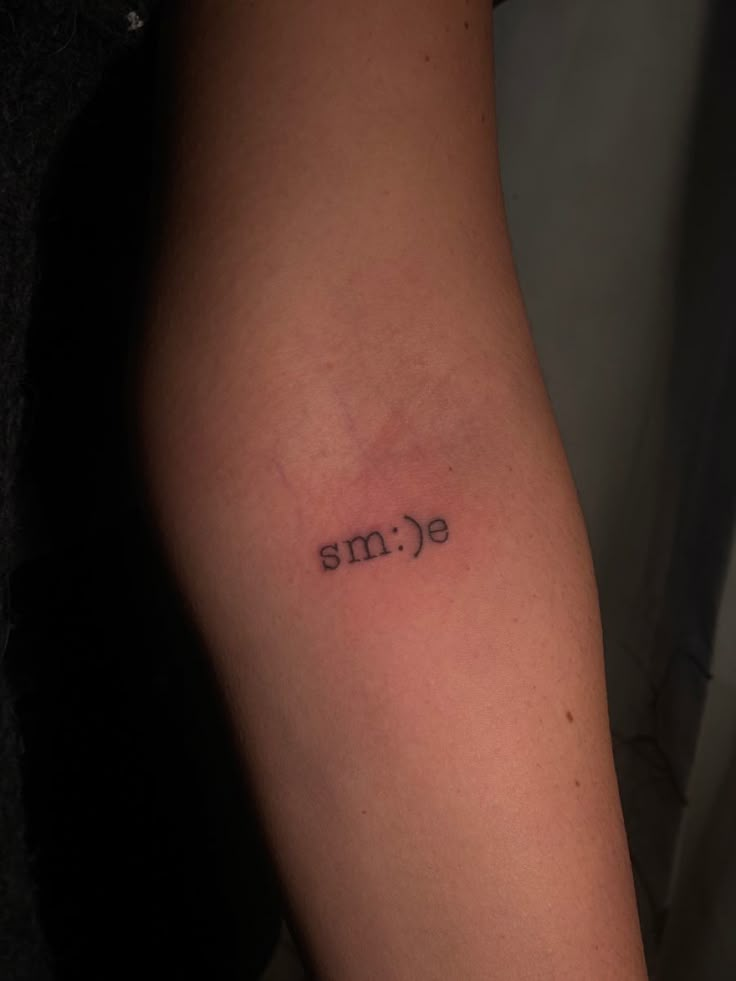 a person with a tattoo on their arm that says eme in small letters,