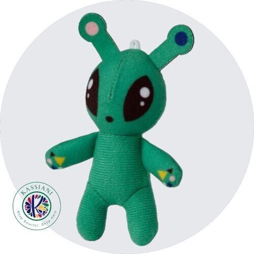 a green stuffed animal with big eyes and an ear tag on it's head