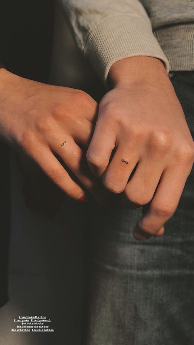 a person with their hand on the other side of his arm, wearing a ring