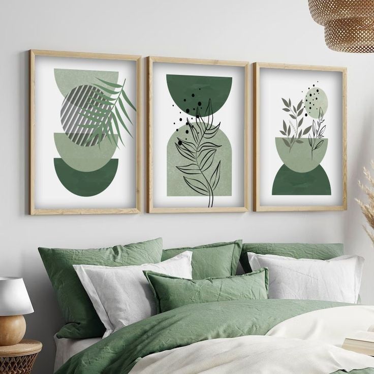 three framed art prints on the wall above a bed with green sheets and pillows in a bedroom