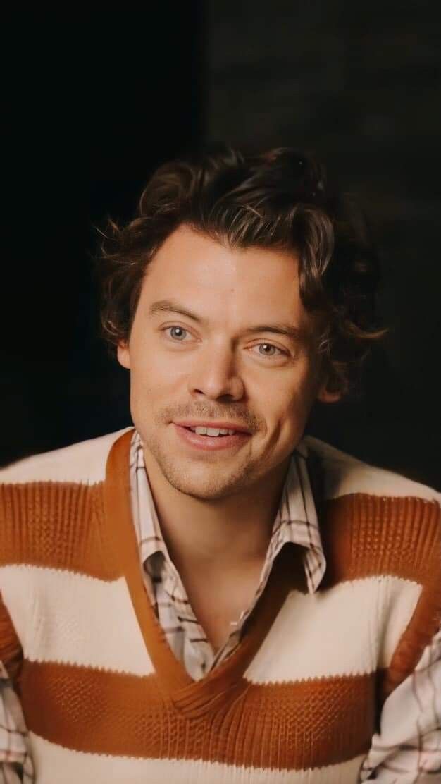 a man with curly hair wearing a striped sweater