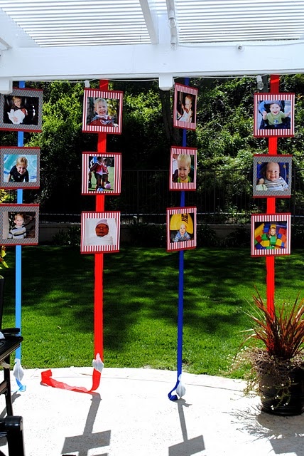 some red and blue poles with pictures on them in front of a green lawn area