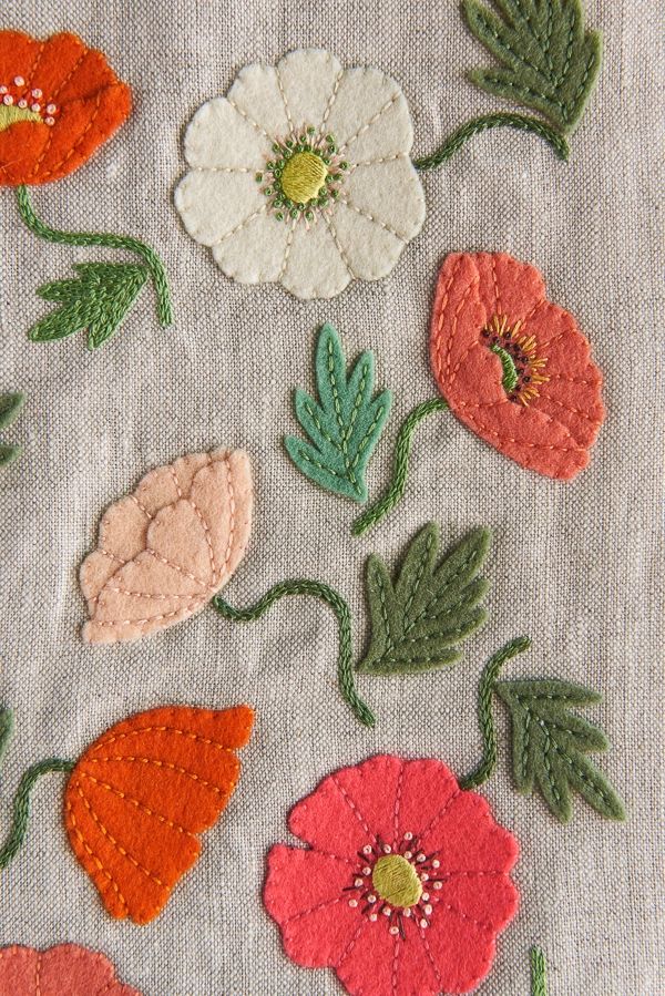 an embroidered piece of cloth with flowers on it