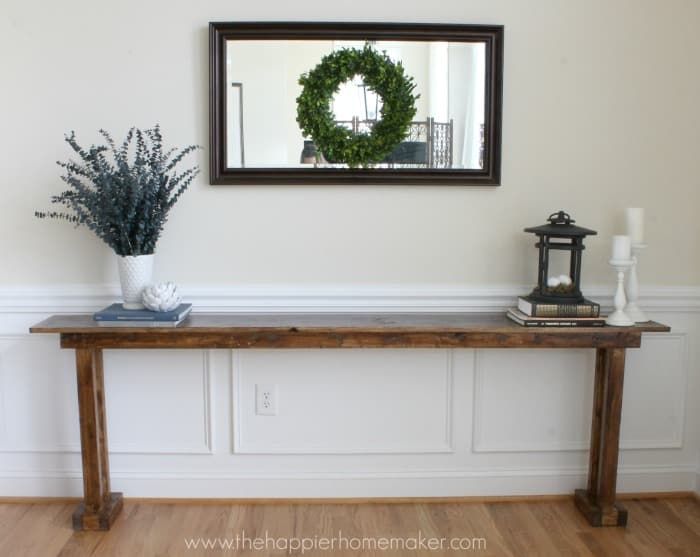 a wooden table topped with a mirror and a potted plant